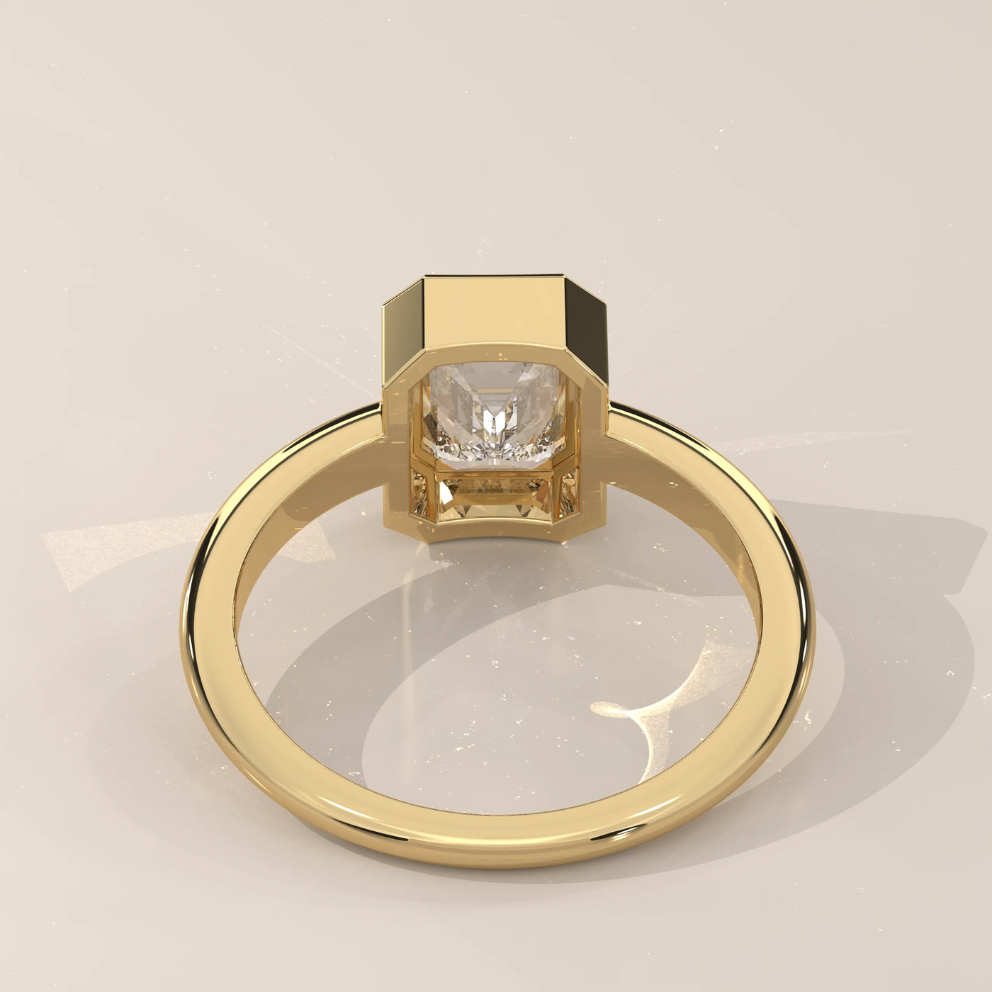 A 14k yellow gold ring with a bezeled emerald-cut diamond, shown from the back.