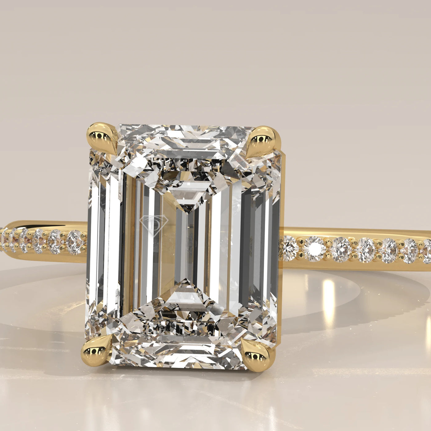 Emerald cut diamond ring in yellow gold with pave diamond band.