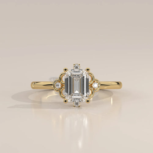 Elegant 14k yellow gold ring with an emerald-cut diamond and smaller accent stones.
