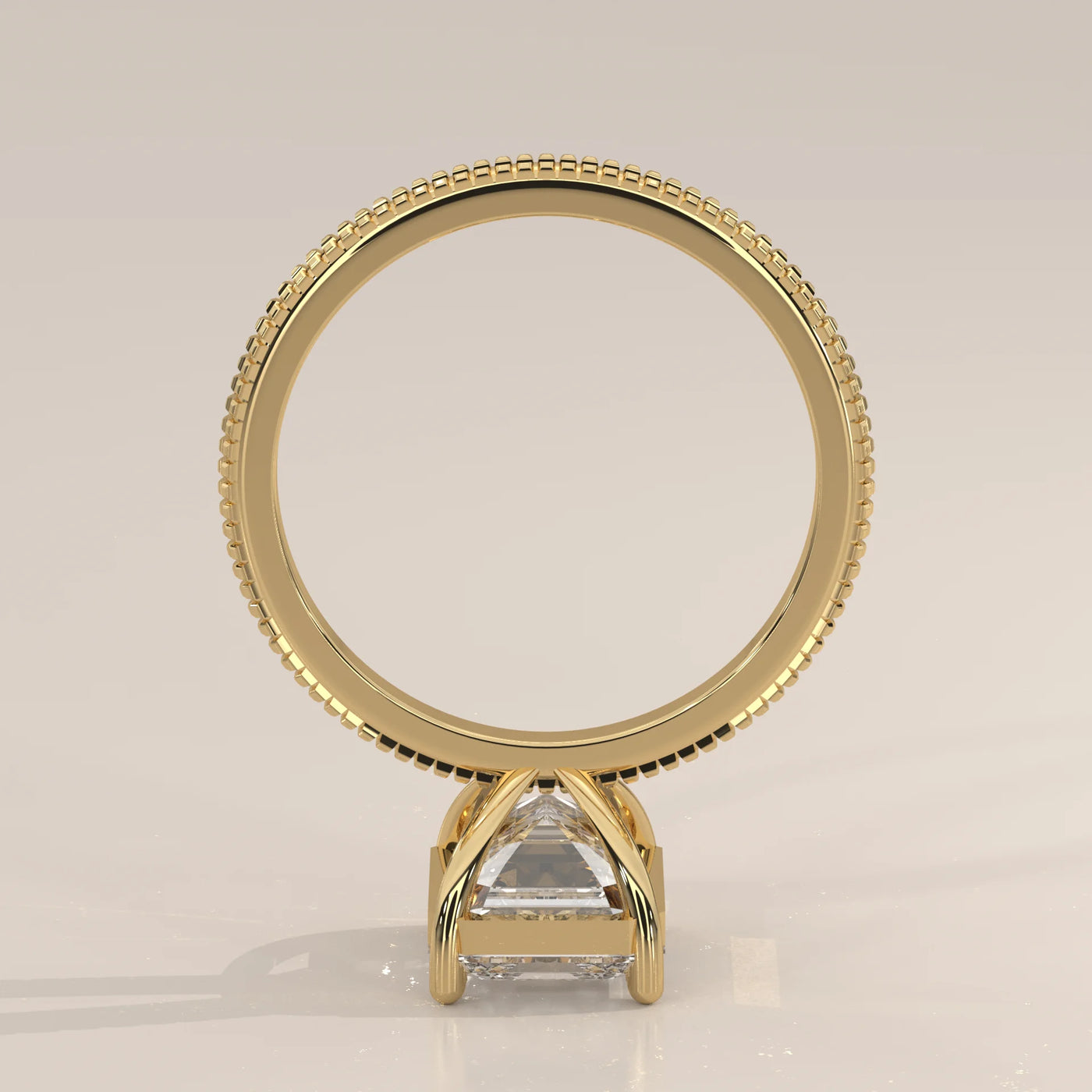 Yellow gold ring with an emerald-cut diamond on a low angle view.