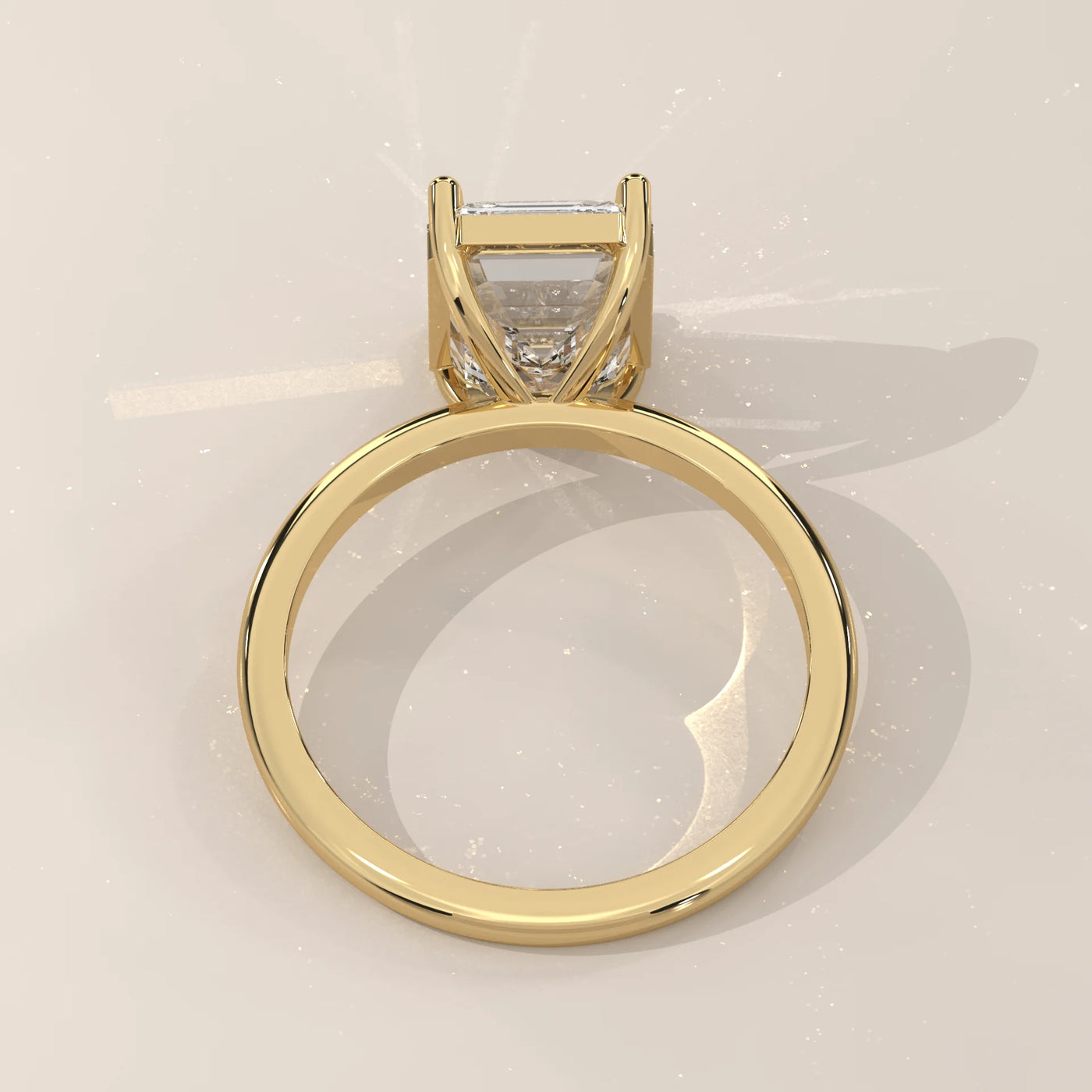 A 14k yellow gold ring with an emerald-cut diamond and pavé band.