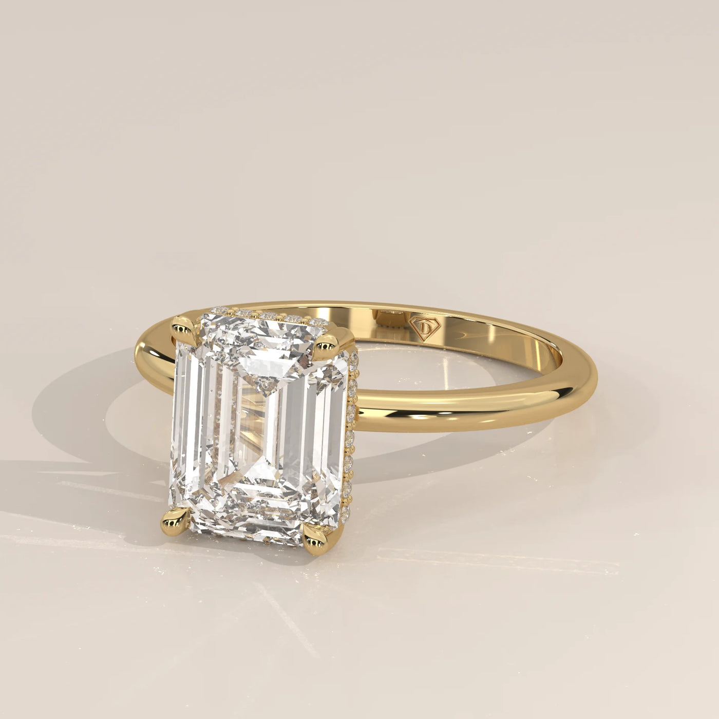 A 14k yellow gold ring with an emerald-cut diamond and pavé band.