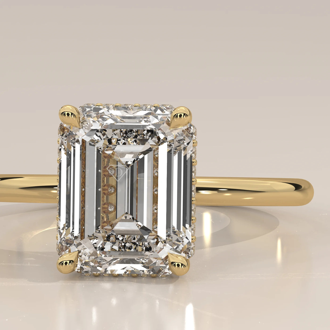 A 14k yellow gold ring with an emerald-cut diamond and pavé band.