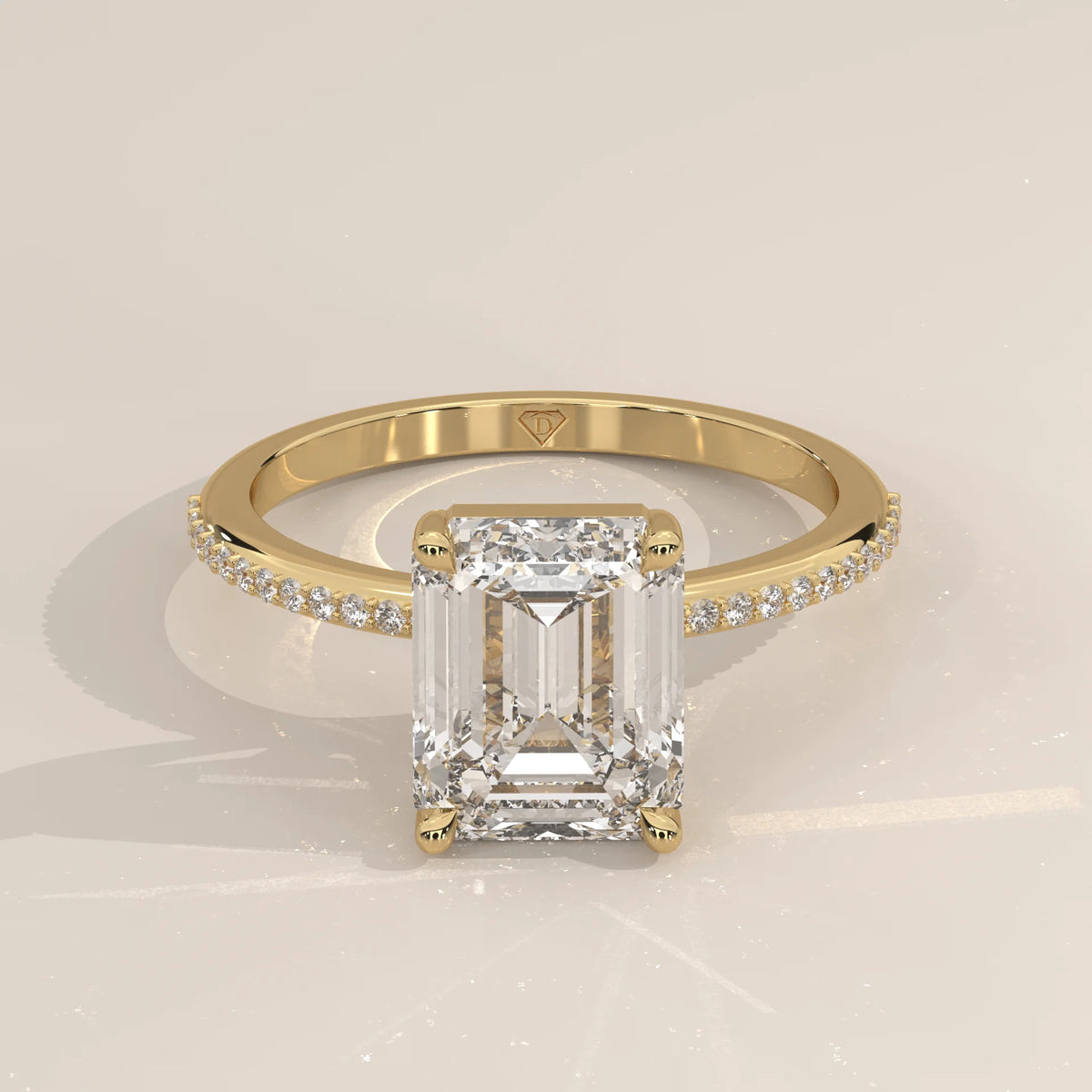 Emerald cut diamond engagement ring in yellow gold with pavé band.