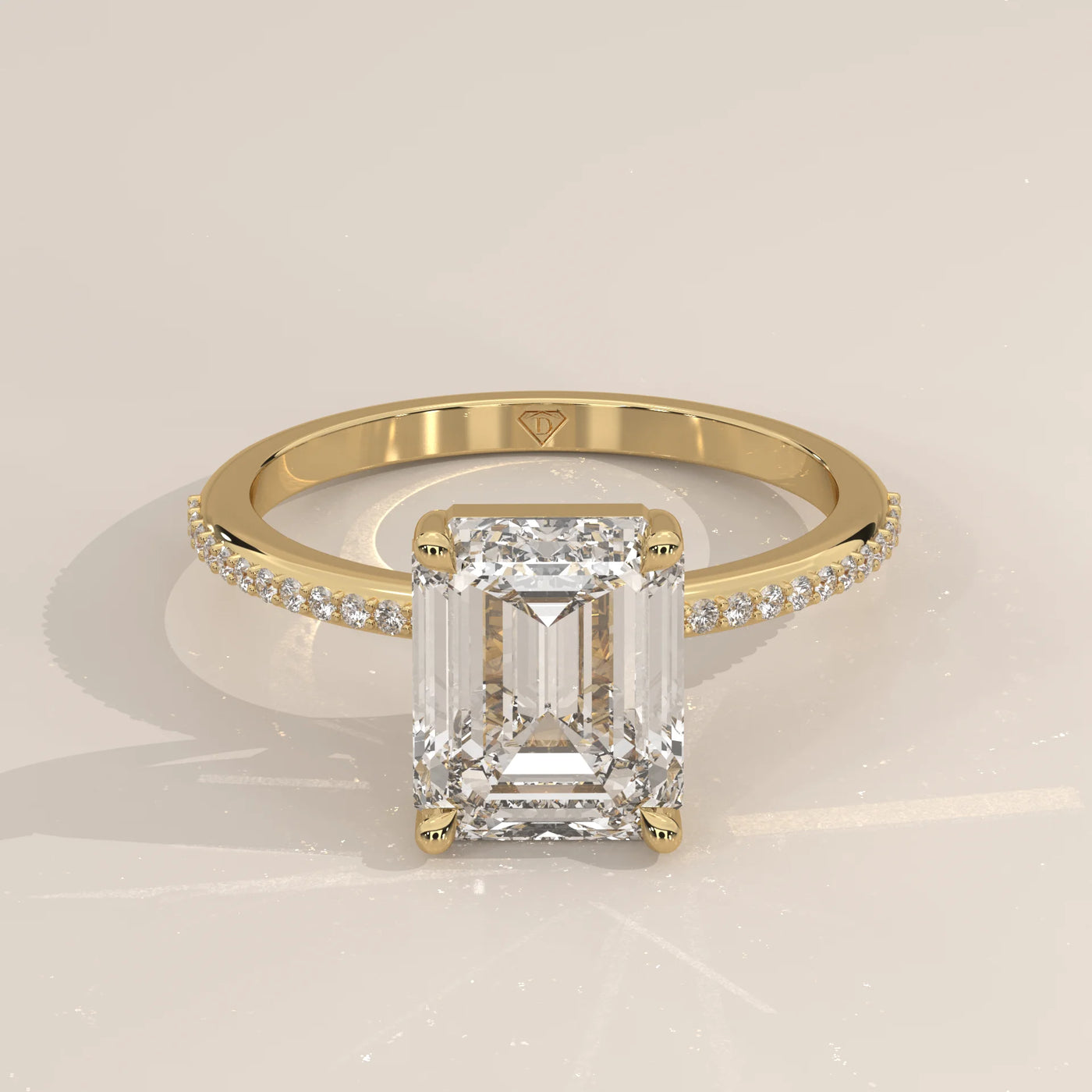 Emerald cut diamond engagement ring in yellow gold with pavé band.