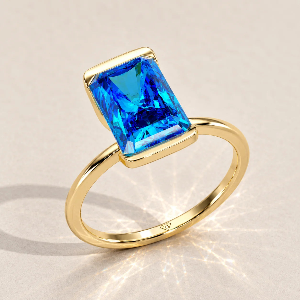 Gold ring with an emerald-cut blue topaz gemstone.