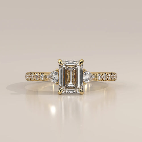 Emerald Cut Lab Grown Diamond Three Stone Ring with Trillion Sides in yellow gold, photographed head-on.