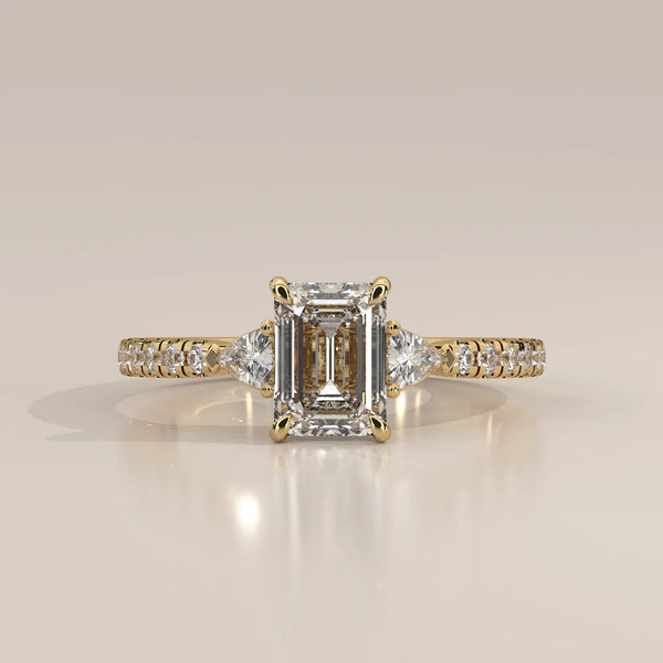 Emerald Cut Lab Grown Diamond Three Stone Ring with Trillion Sides in yellow gold, photographed head-on.