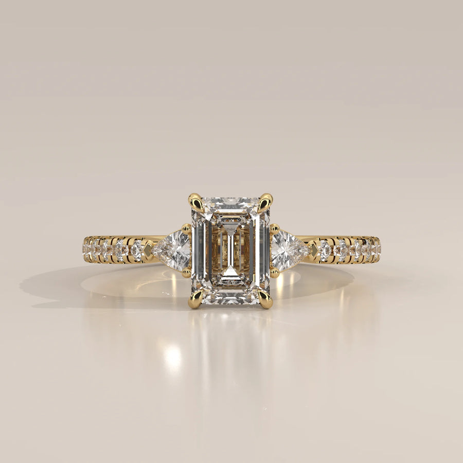 Emerald Cut Lab Grown Diamond Three Stone Ring with Trillion Sides in yellow gold, photographed head-on.