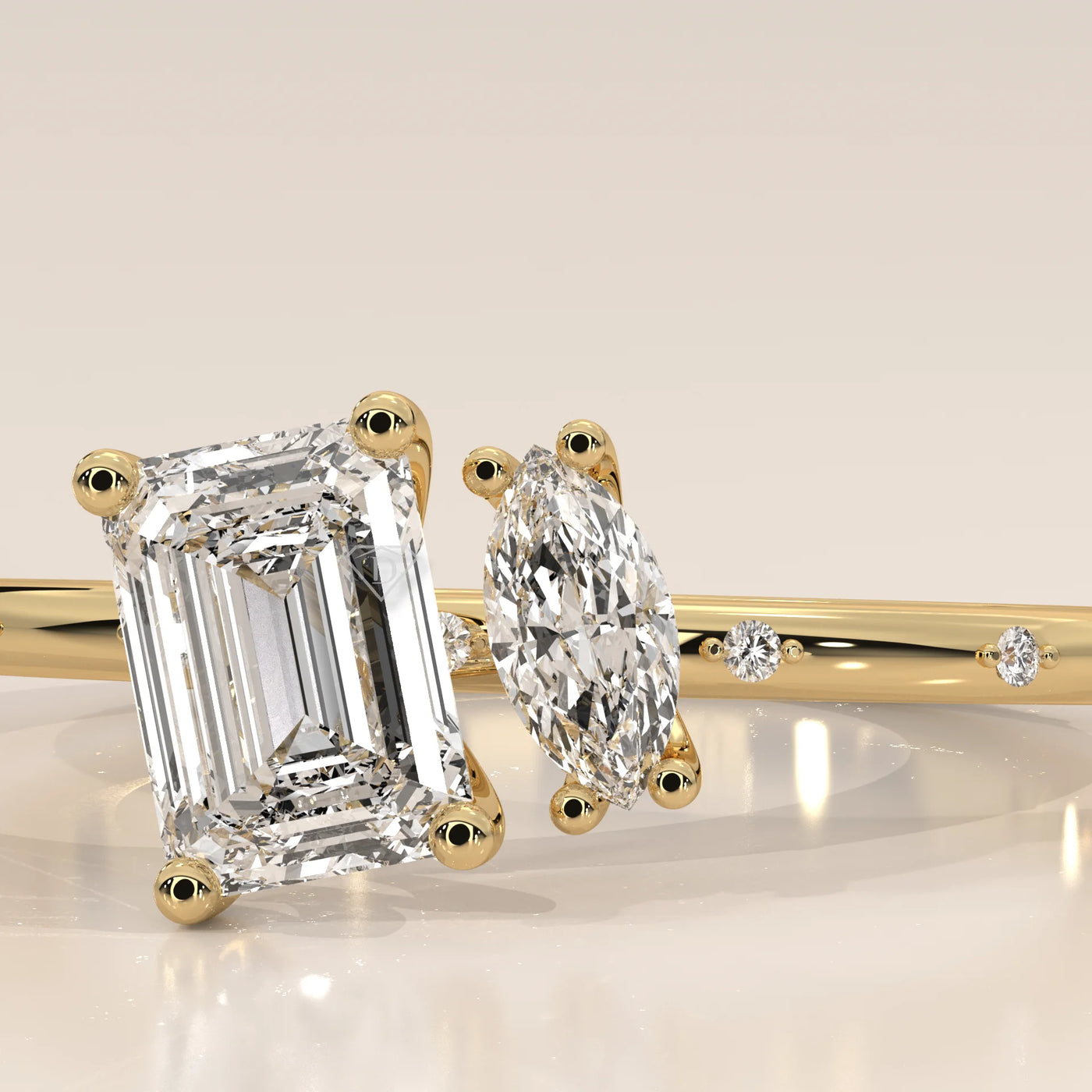 Close-up angled view of a yellow gold ring featuring an emerald-cut and a marquise-cut diamond.