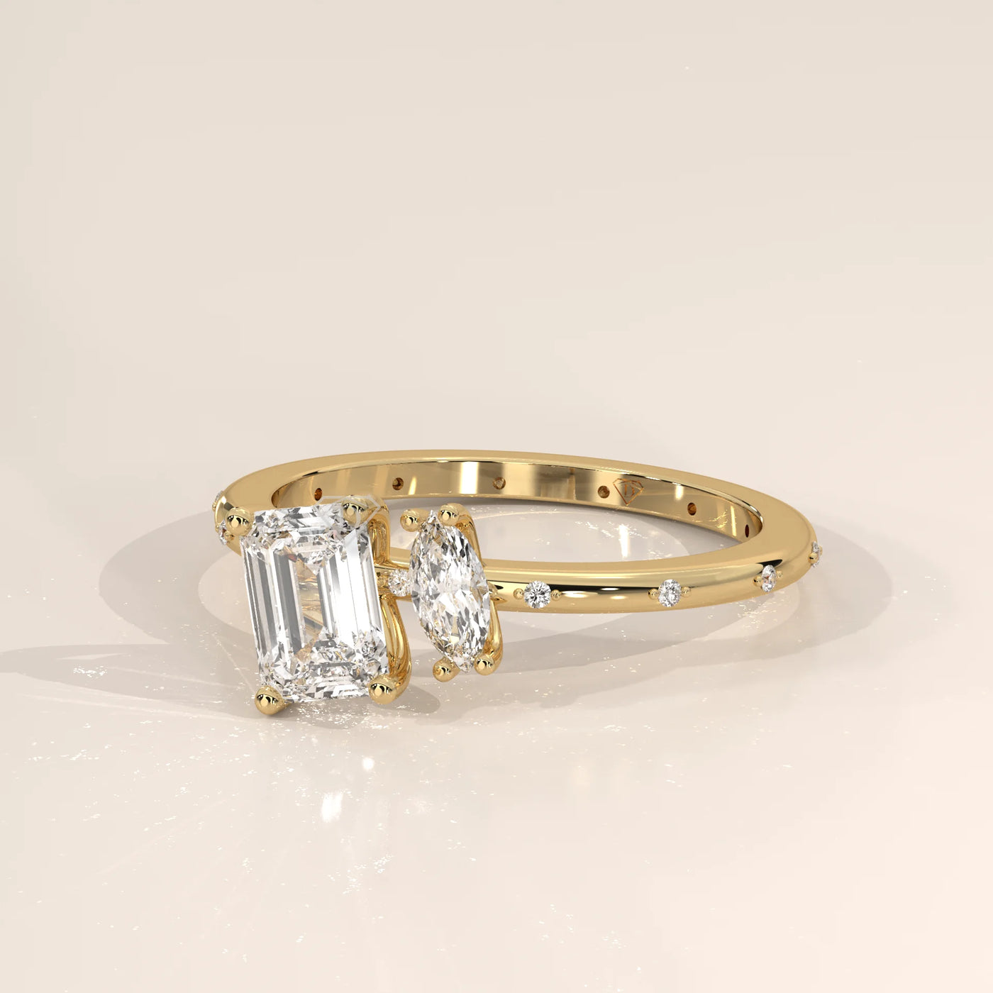 A delicate gold ring featuring an emerald-cut diamond and an oval-cut diamond.
