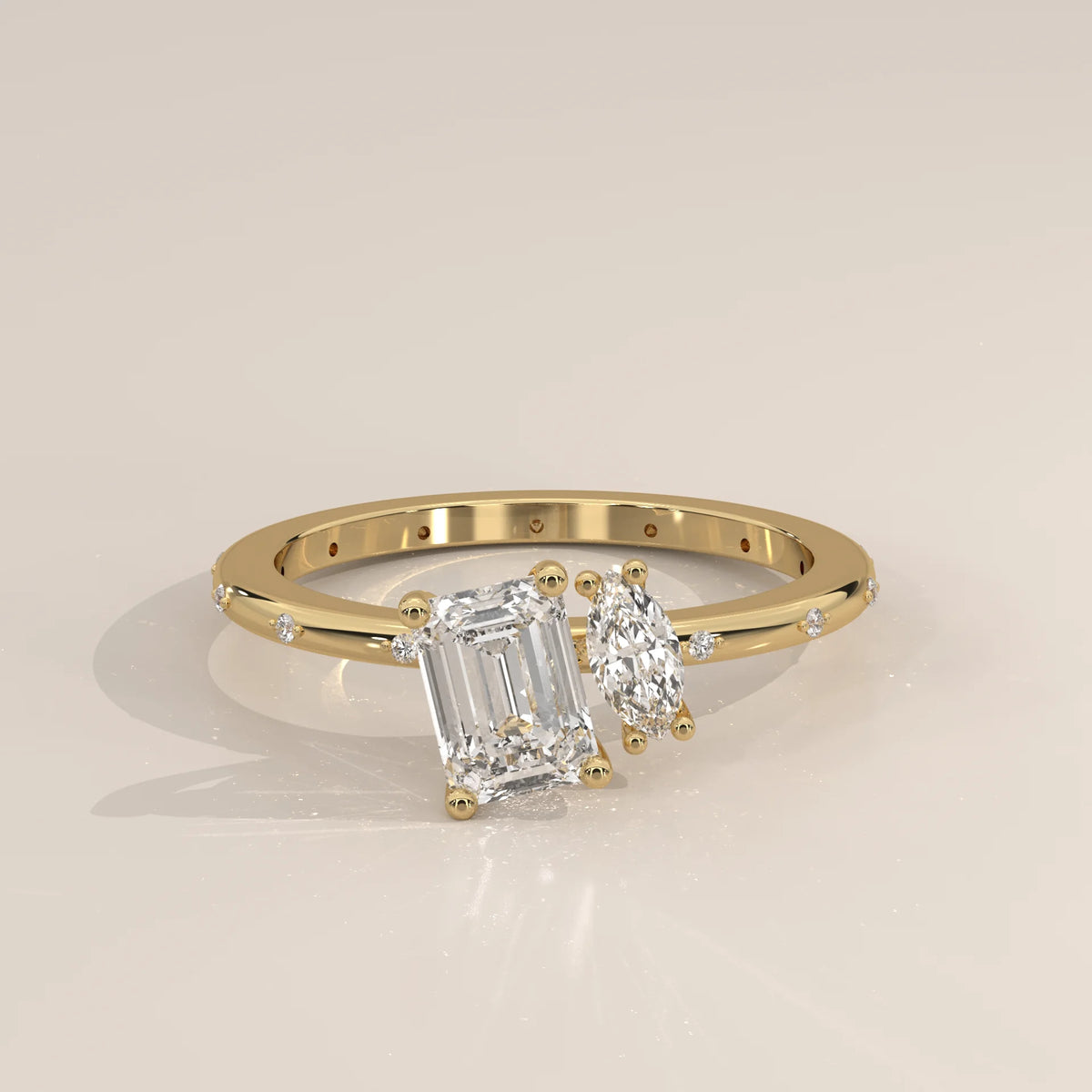 A yellow gold ring with an emerald-cut and pear-cut diamond.