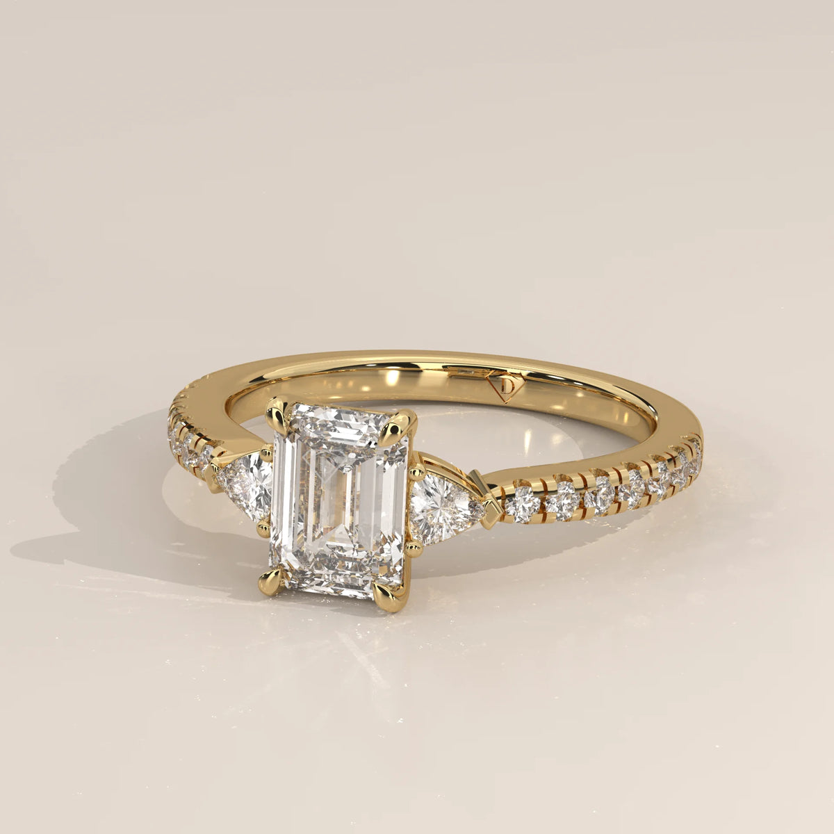 Emerald Cut Lab Grown Diamond Three Stone Ring with Trillion Sides in yellow gold, front view on a plain background.