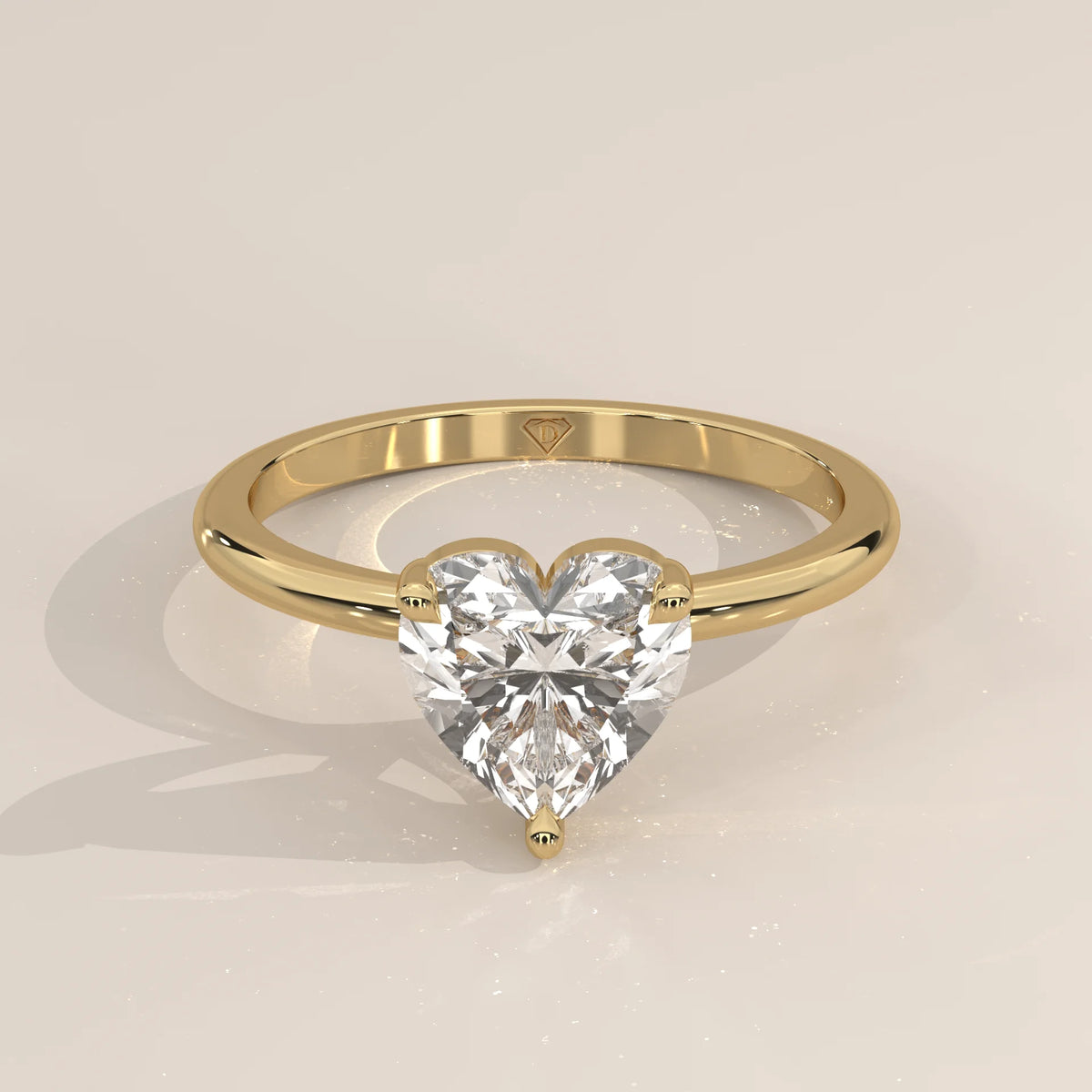 A yellow gold ring with a heart-shaped diamond in a bezel setting.