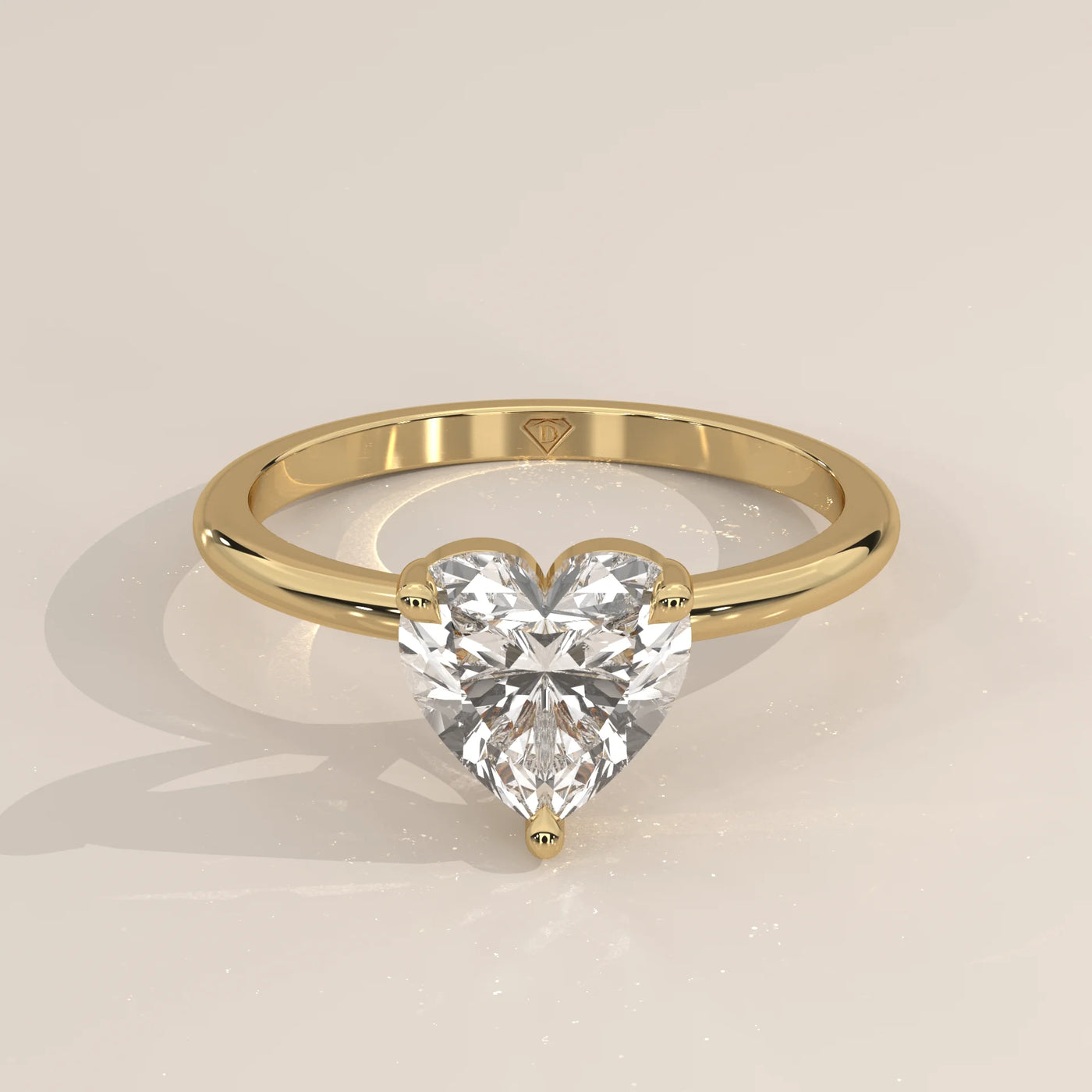 A yellow gold ring with a heart-shaped diamond in a bezel setting.