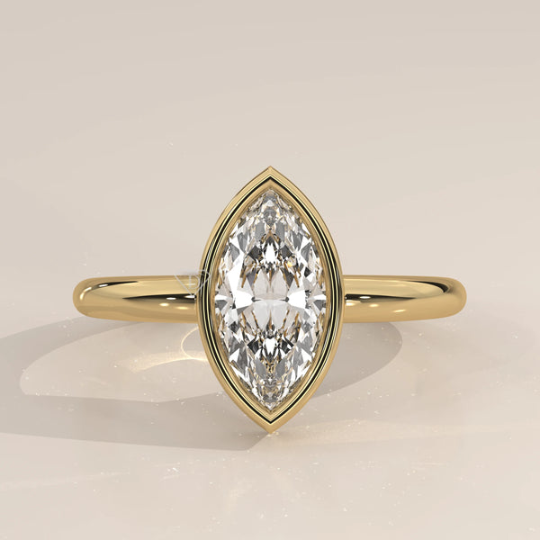 A yellow gold ring with a bezel-set marquise diamond.