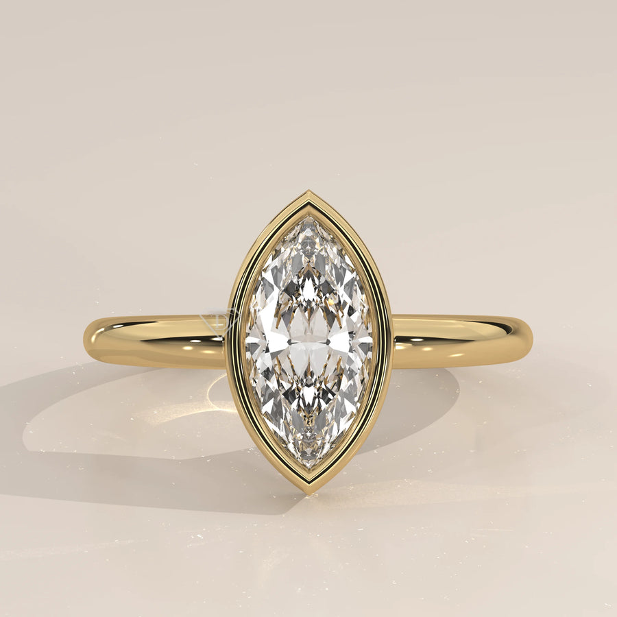 A yellow gold ring with a bezel-set marquise diamond.