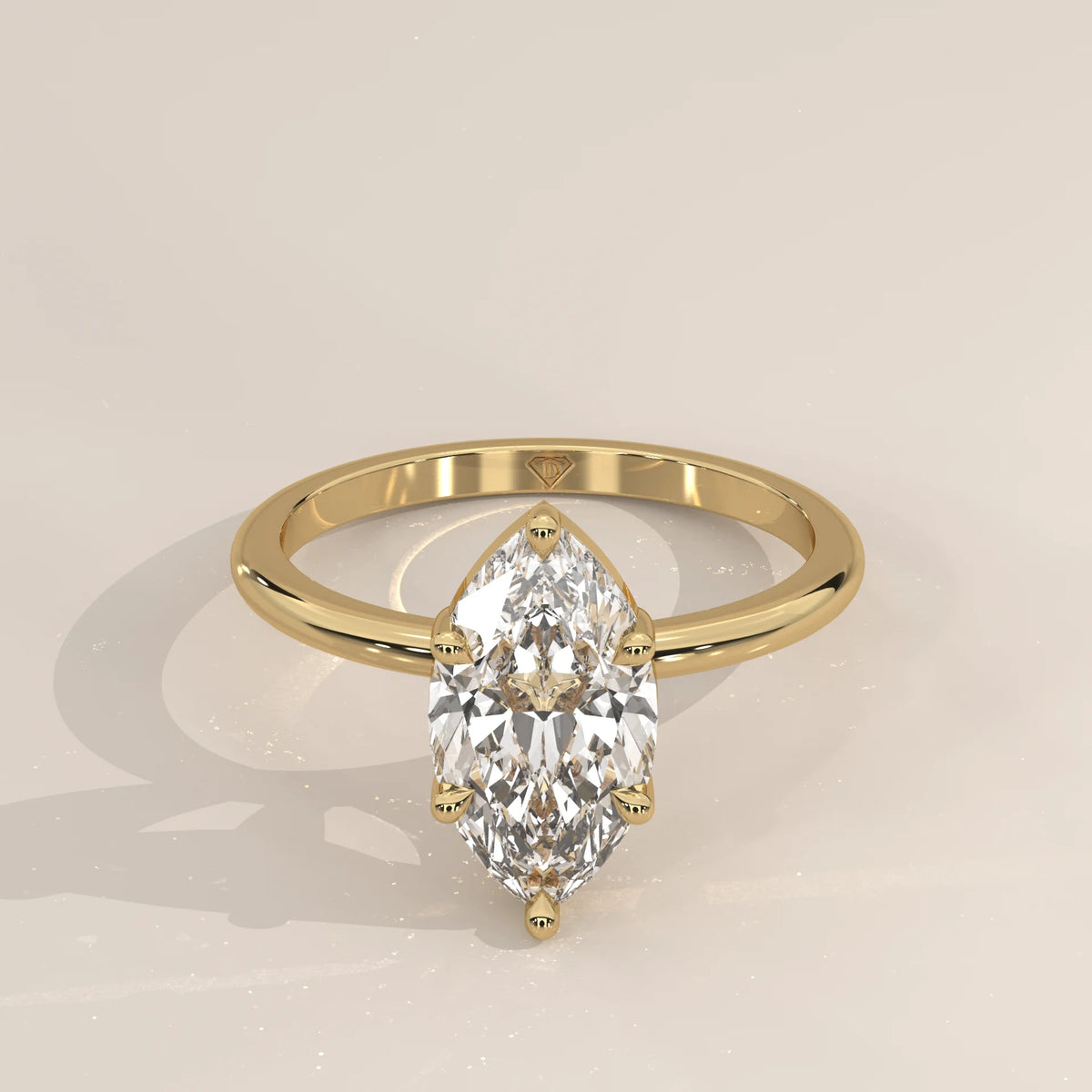 Yellow gold ring with a marquise-cut diamond in a bezel setting.