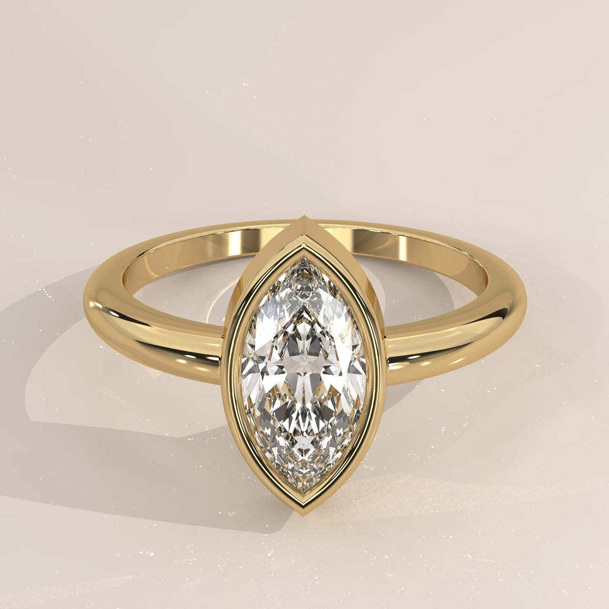 Yellow gold ring with a marquise-cut diamond in a bezel setting.