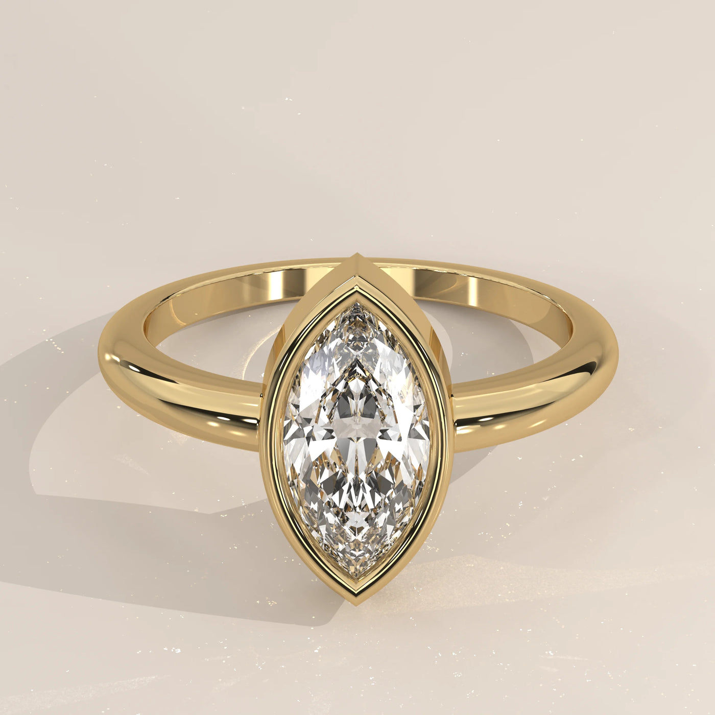 Yellow gold ring with a marquise-cut diamond in a bezel setting.