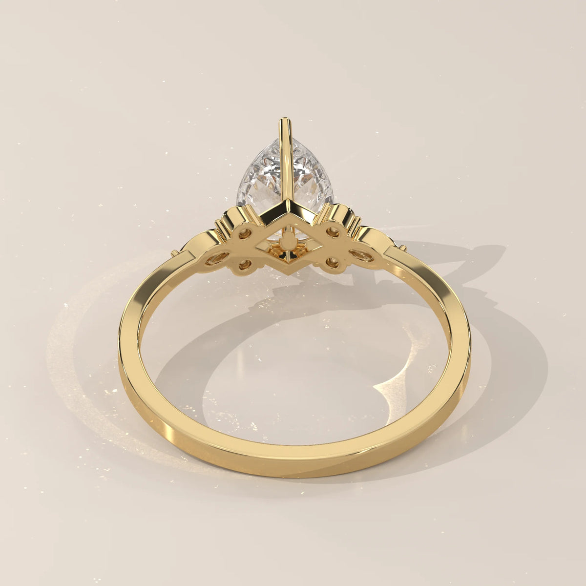 Yellow gold ring with a pear-cut diamond and delicate side detailing.