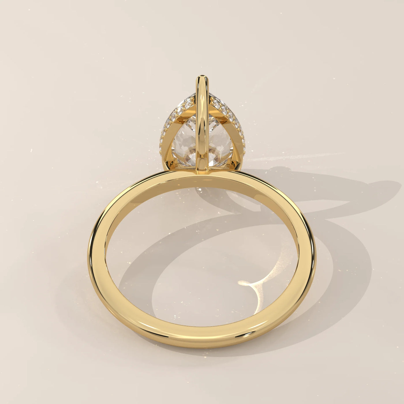 A classic 14k yellow gold ring with a pear-cut diamond and pave accents.