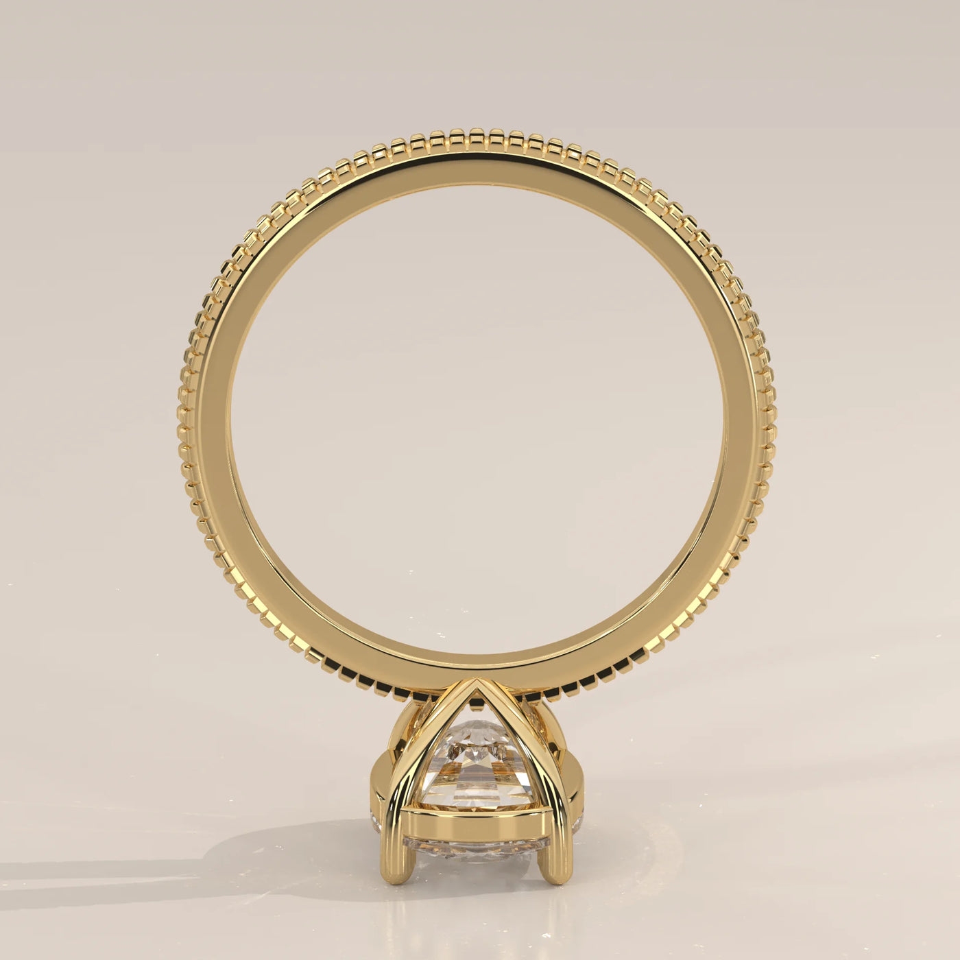 A solitaire pear-shaped diamond ring in a yellow gold bezel setting.
