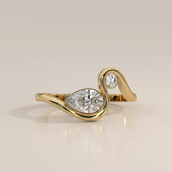 Pear Lab Grown Diamond Swirl Ring with Bezel Set Round Accent in yellow gold, photographed from the side.