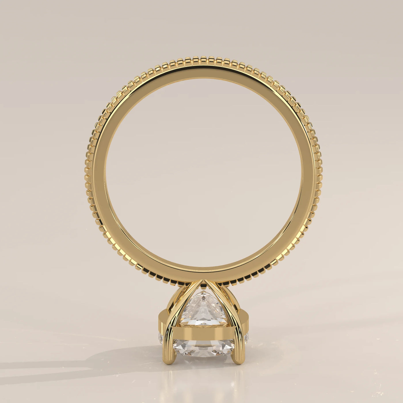 A solitaire pear-shaped diamond ring in a yellow gold bezel setting.