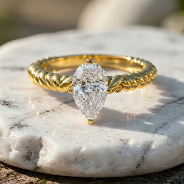 Flat Lay: Pear Cut Diamond Ring with Solitaire Setting in 14k Yellow Gold - Lab Grown - Driona Jewels