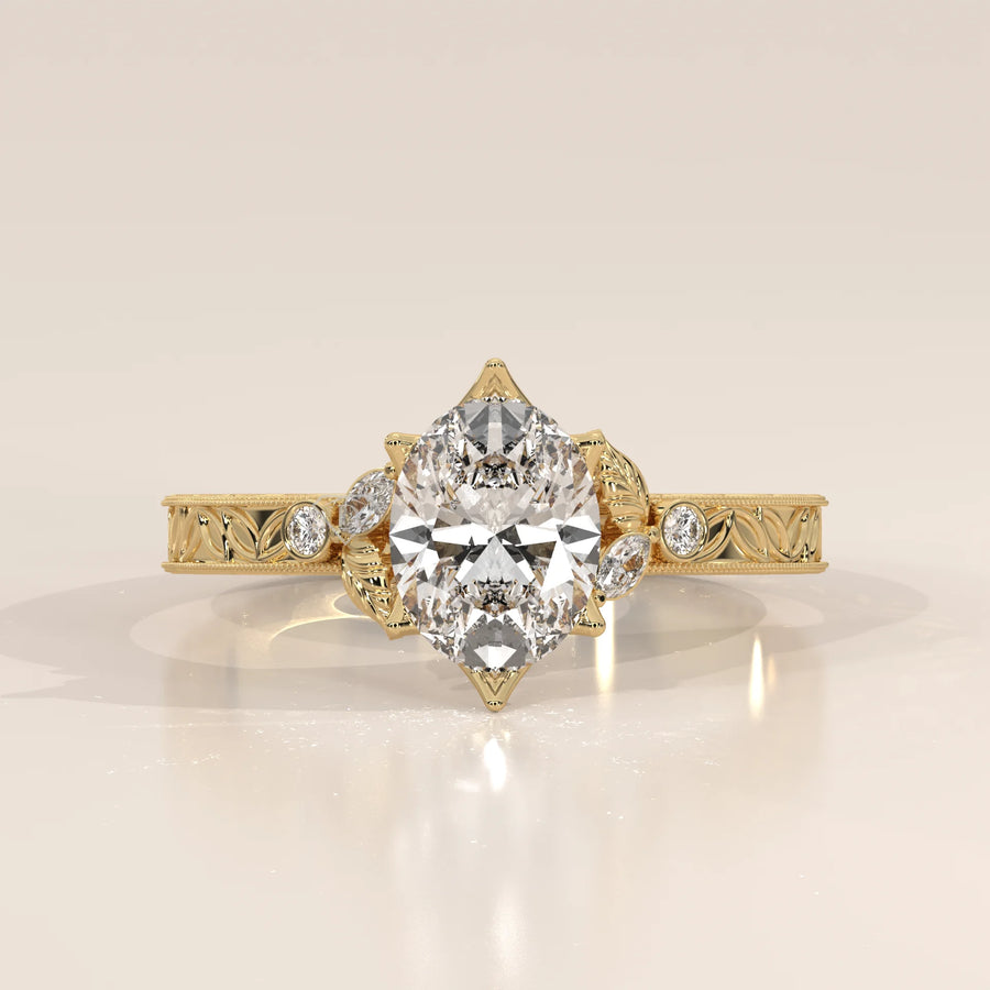 Pear shaped diamond engagement ring in yellow gold with intricate detailing.