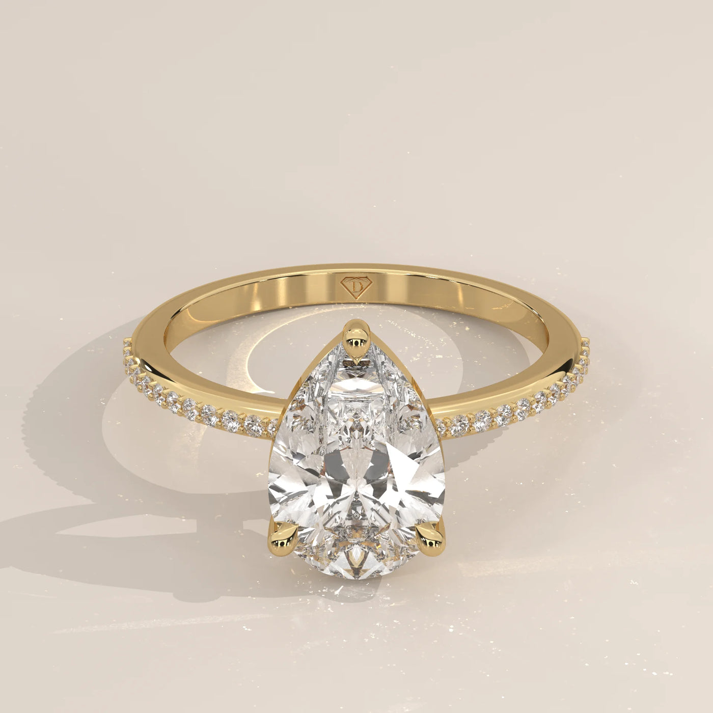 Pear-shaped diamond engagement ring in yellow gold with pave band.