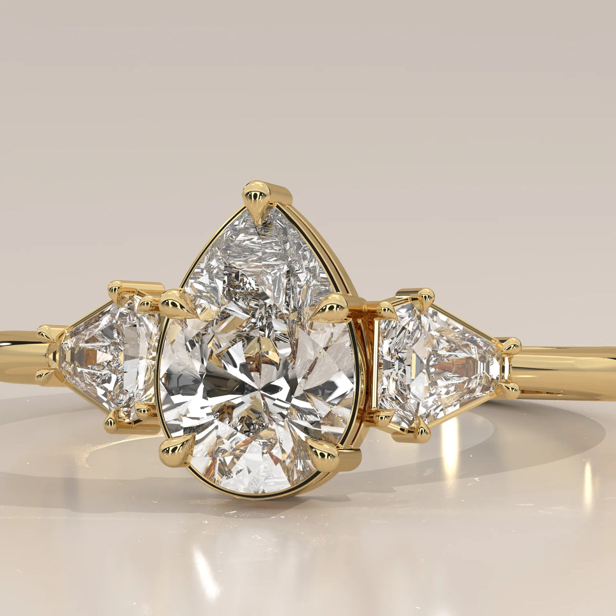 Pear Lab Grown Diamond Three Stone Ring with Shield Cut Sides in yellow gold, front view on a plain background.
