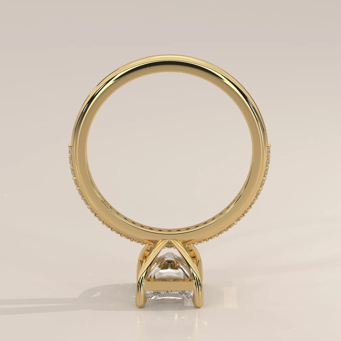 A princess-cut diamond engagement ring set in 14k yellow gold with pave detailing.