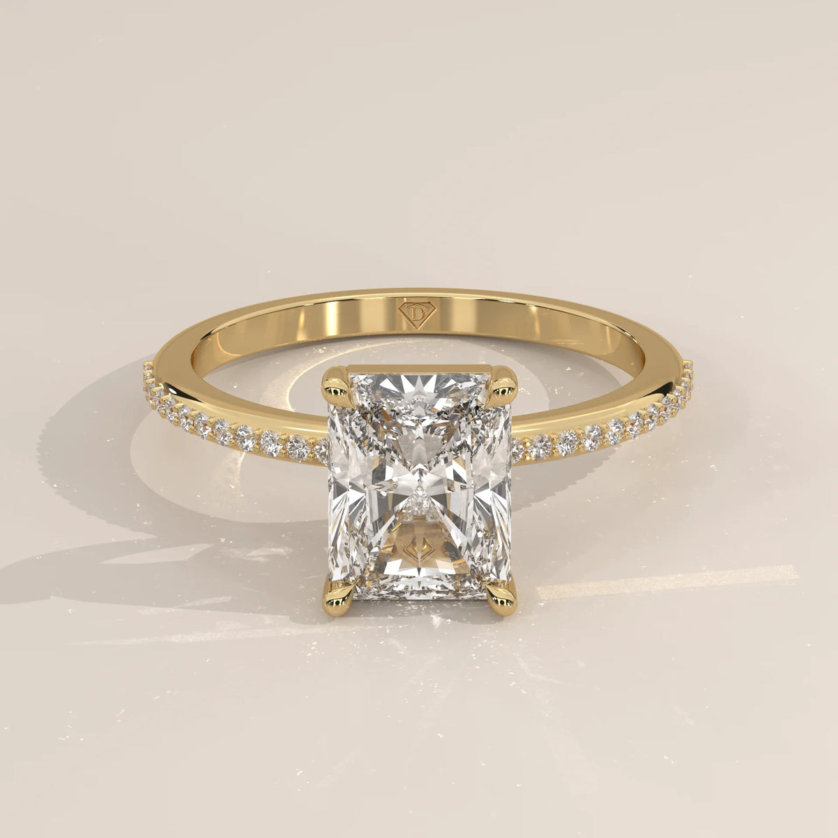 Yellow gold engagement ring with a radiant-cut diamond and pave band.
