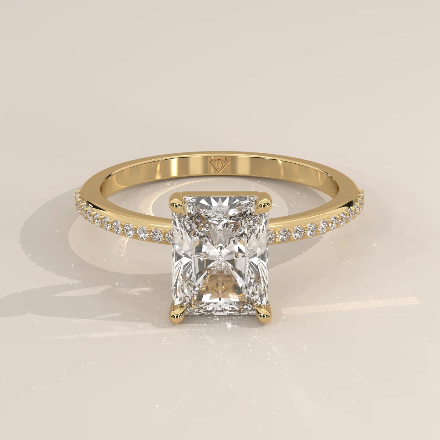 Yellow gold engagement ring with a radiant-cut diamond and pave band.