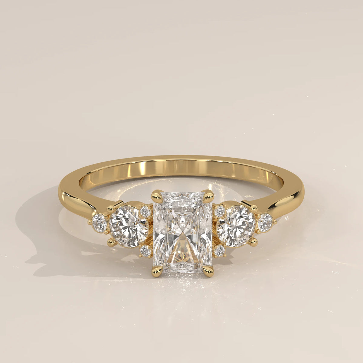 Yellow gold ring with a radiant cut diamond and side stones.