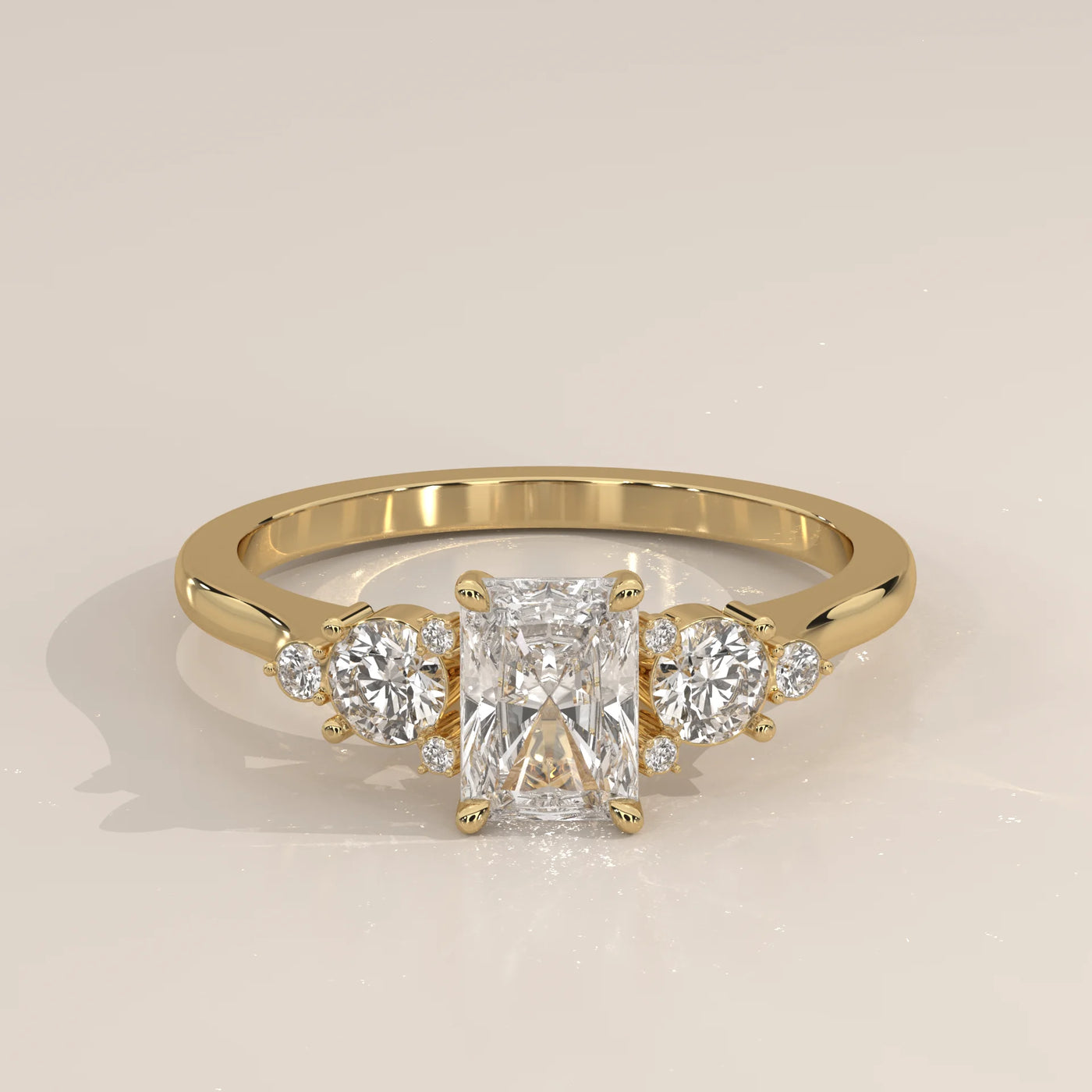 Yellow gold ring with a radiant cut diamond and side stones.