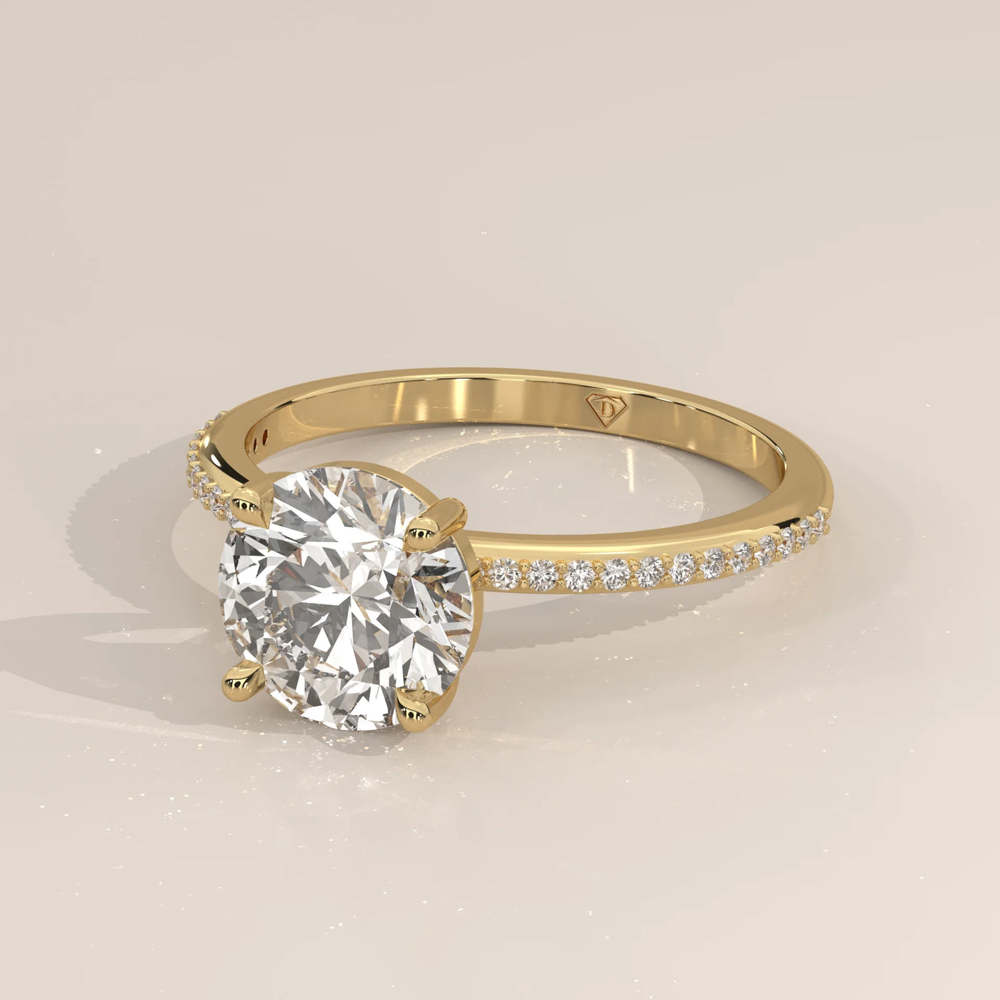 A classic solitaire diamond ring in 14k yellow gold with pavé band details.