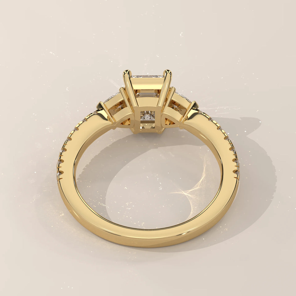 Emerald Cut Lab Grown Diamond Three Stone Ring with Trillion Sides in yellow gold, shown on a plain background.