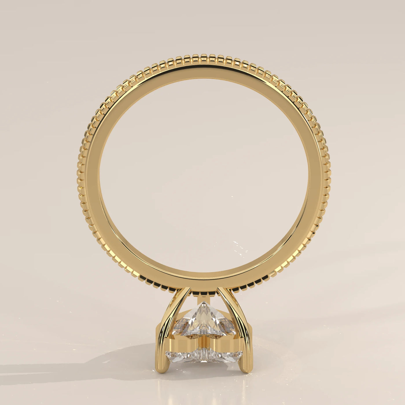 Gold ring with a prong-set trillion-cut diamond on a plain background.