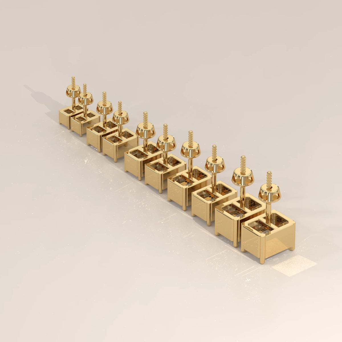 A line of square stud earrings in yellow gold.