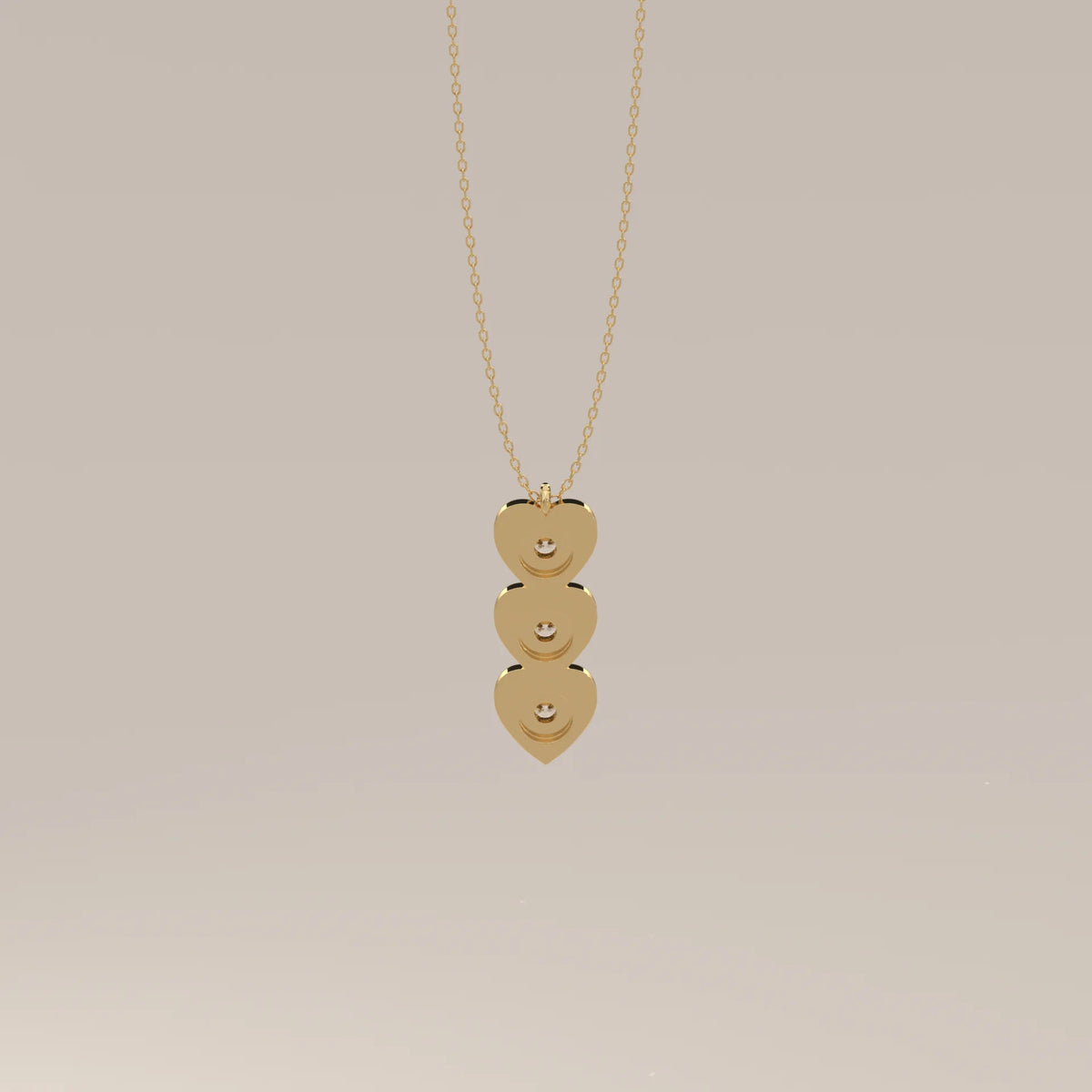 Three Puffed Heart Lab Grown Diamond Drop Pendant with Bezel Rounds in yellow gold, photographed head-on.