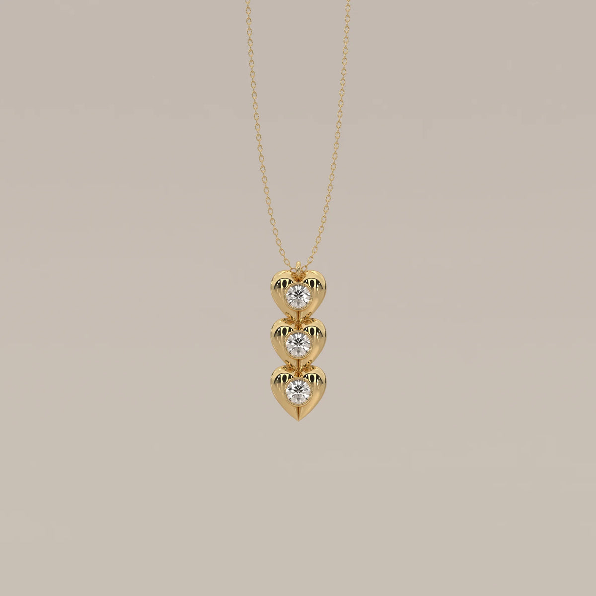Three Puffed Heart Lab Grown Diamond Drop Pendant with Bezel Rounds in yellow gold, shown from the front.