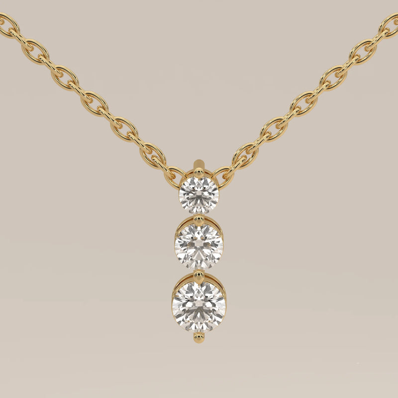 Delicate yellow gold necklace with three shimmering diamonds.