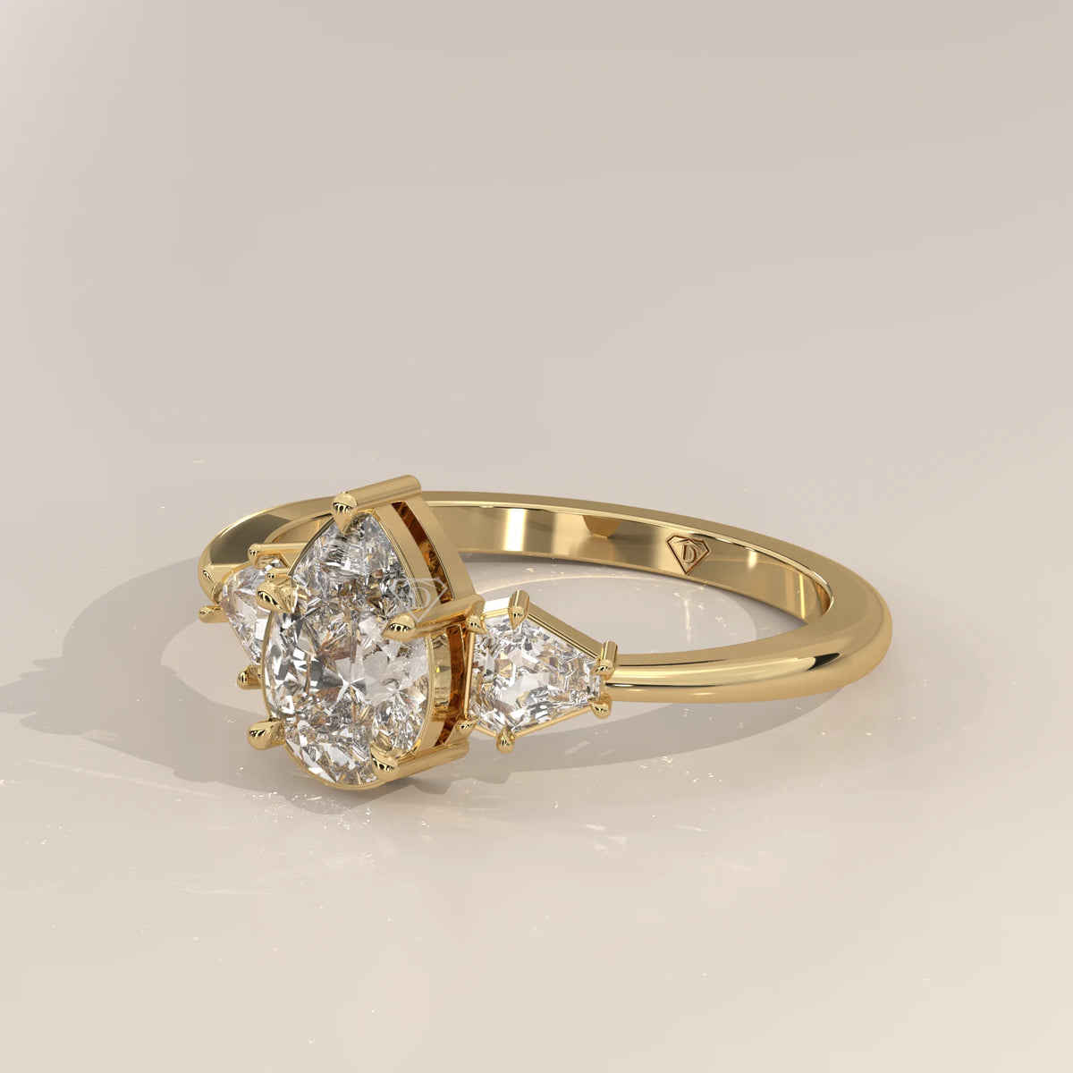 Pear Lab Grown Diamond Three Stone Ring with Shield Cut Sides in yellow gold, shown from the side.