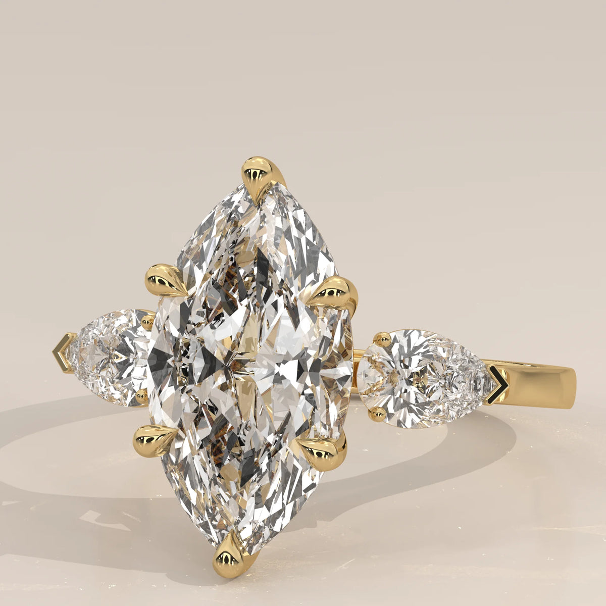 Umor 5 Carat Marquise Lab Grown Diamond Three Stone Ring, Pear Sides in yellow gold, shown at an angle.